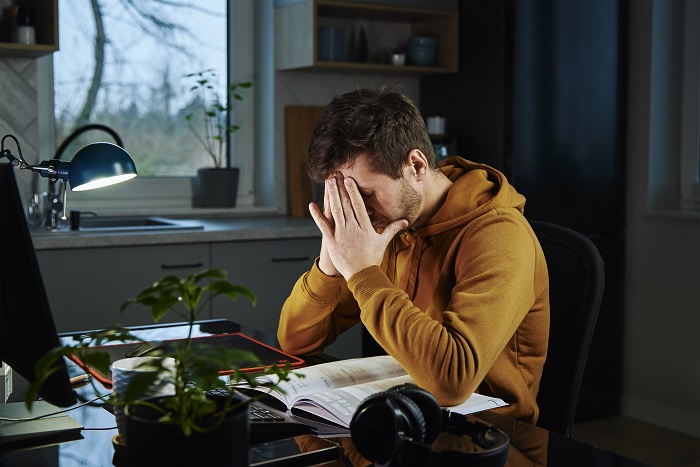 A tired man working remotely from home