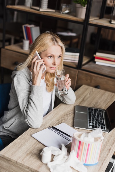 woman keeping herself hydrated while working from home